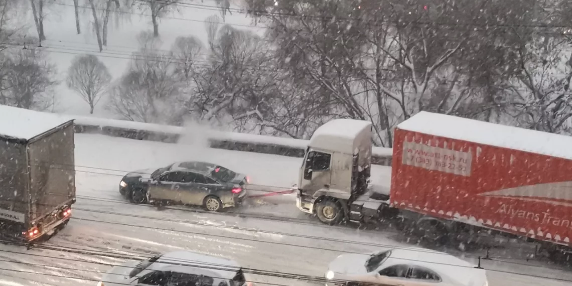 Отпадный снегопад: легковушки вытягивают застрявшие из-за гололёда фуры на Большевистской (видео)