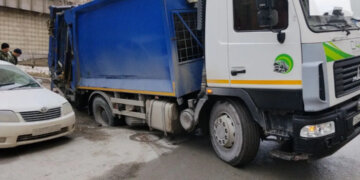 Мусоровоз провалился под асфальт в Новосибирске на улице Октябрьской