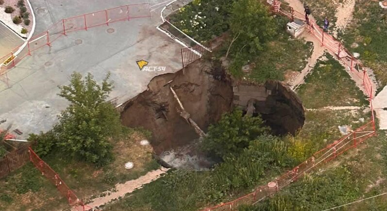Провал в новосибирском микрорайоне Горский продолжает расширяться: в яму рухнули дерево и асфальт